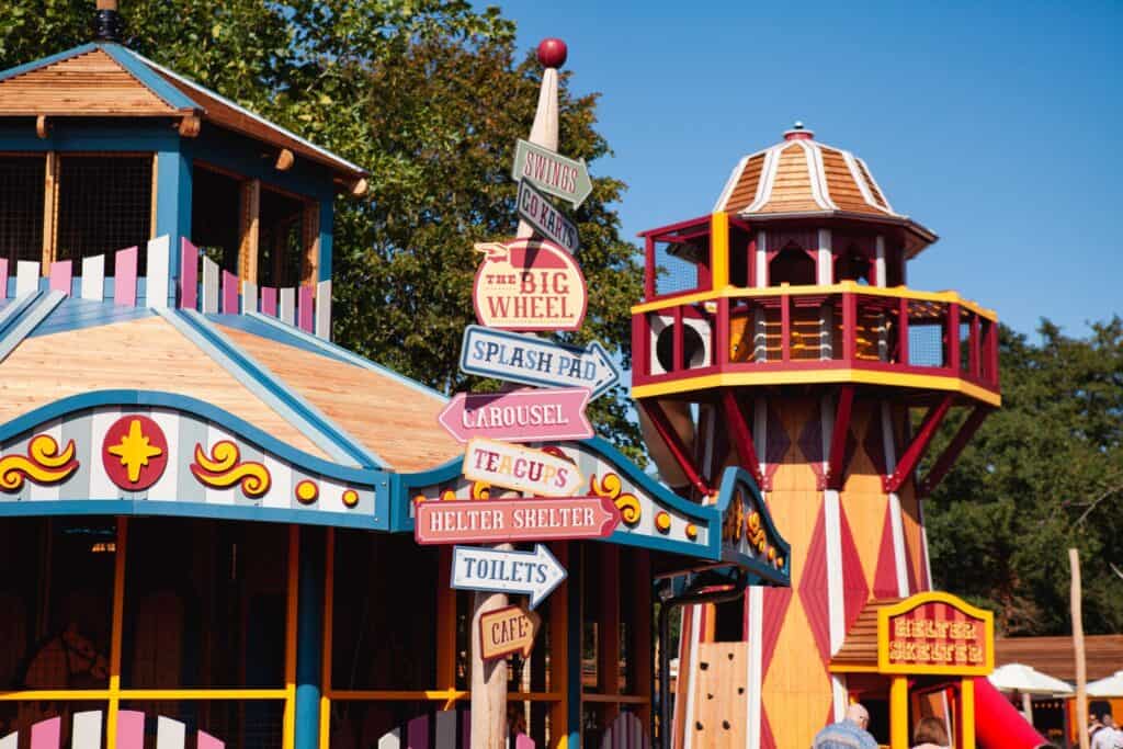 Vibrant playground with rides, signs, and seating areas for family fun.
